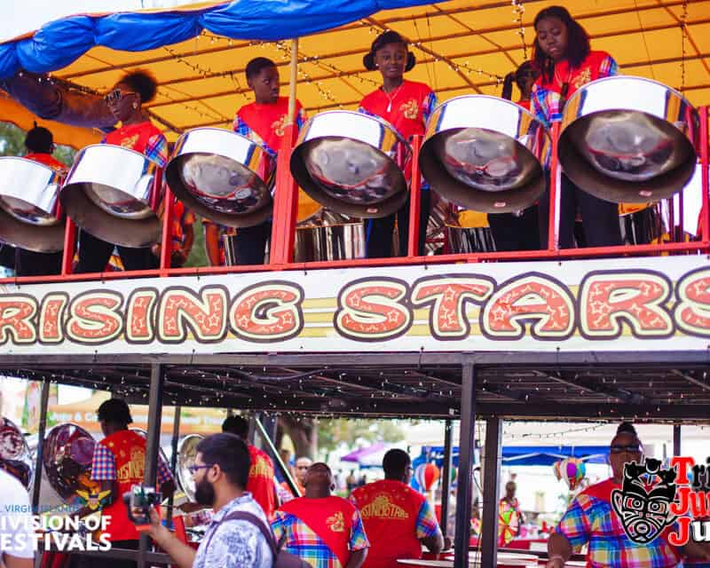 A group of musicians play steel drums on a double-decker float decorated with 